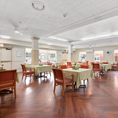 Dining area with tables and chairs set for meals.
