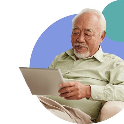 Senior man using a tablet, smiling.
