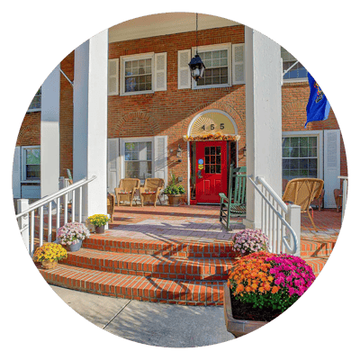 Front entrance with flowers and flags.