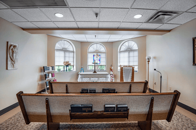 Serene chapel interior with seating and stained glass
