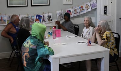 Residents engaging in a group activity at a communal table.