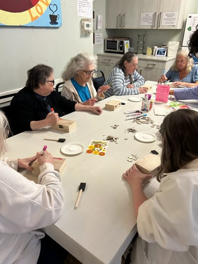 Residents engaged in a craft activity at a table.