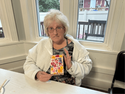 Resident creating art in an indoor common area.
