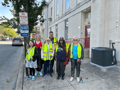 Residents and staff posing outside the facility in safety vests.