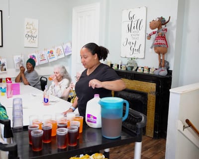 Care staff serving drinks to residents in a common area