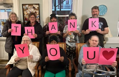Residents holding signs expressing gratitude.