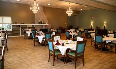 Dining area with elegant chandeliers and tables set for meals.