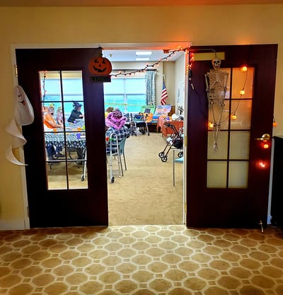 Entrance to a decorated community room with residents