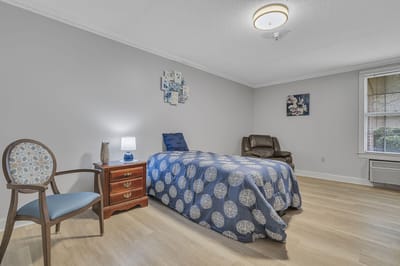 Cozy private resident room with a bed and chair