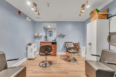 Beauty salon area with styling chairs and equipment.