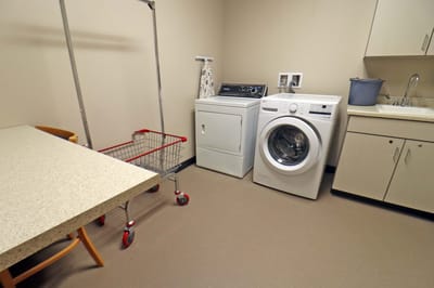 Laundry room with washing machines and carts.