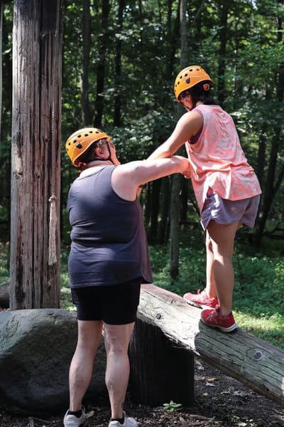 Resident assisting child in an outdoor activity.