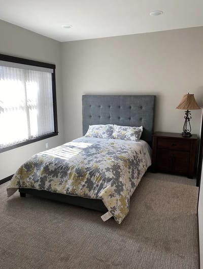 Cozy bedroom with floral bedding and bedside lamp.