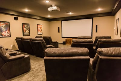 Cozy theater room with reclining seats and screen