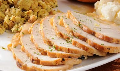Sliced turkey with stuffing on a plate.
