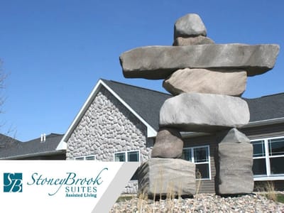 Exterior view of StoneyBrook Suites with logo
