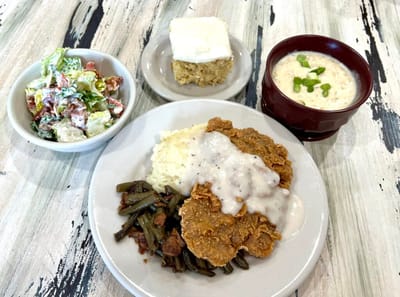 Hearty meal with fried chicken, salad, and dessert.