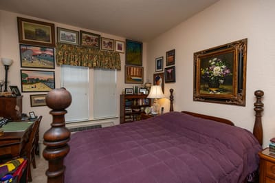 Cozy resident room with artwork and furniture.