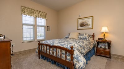 Cozy private bedroom with floral bedding and lamp.