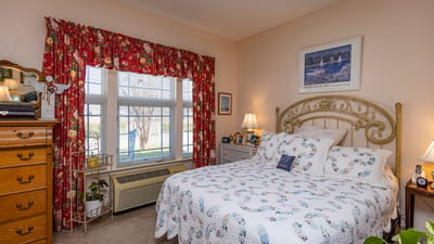 Cozy bedroom with floral curtains and a comfortable bed.
