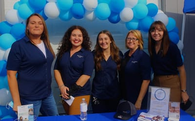 Staff members smiling at a community event
