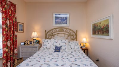 Cozy bedroom with floral decor and lights.