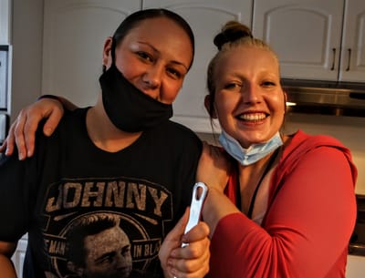 Two staff members smiling together in the kitchen.