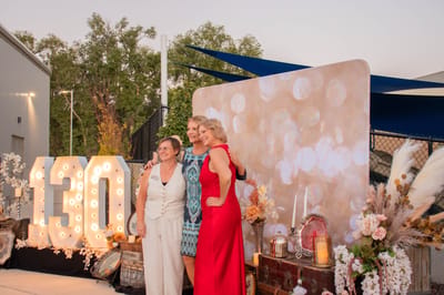 Three women celebrating at an outdoor event.