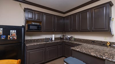 Interior kitchen area with dark cabinets and appliances.