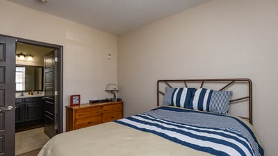 Cozy bedroom with a bed and bathroom entrance.