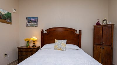 Cozy bedroom with wooden furniture and decorations.