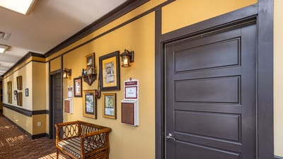 Interior hallway with framed photos and seating.