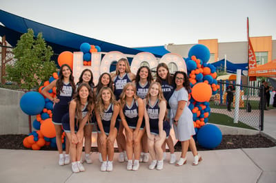 Cheerleading team poses at an event with decorations.
