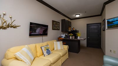 Cozy interior of a resident's room with a yellow couch.