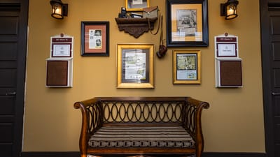 Decorative wall with framed pictures and a bench