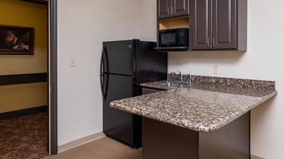 A kitchenette area with granite countertops.
