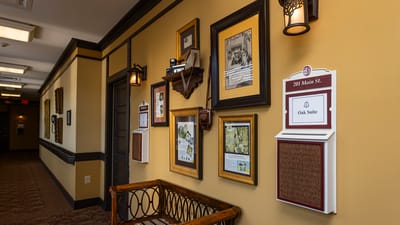 Interior hallway with framed pictures and signage.