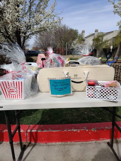 Outdoor event setup with gift baskets on a table.
