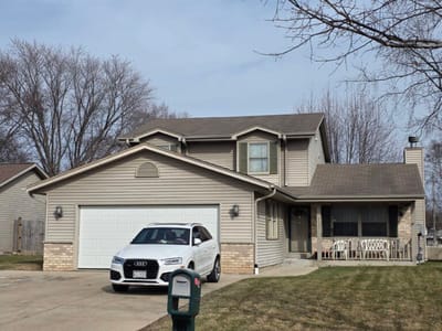 Exterior view of a residential building with a car in driveway.