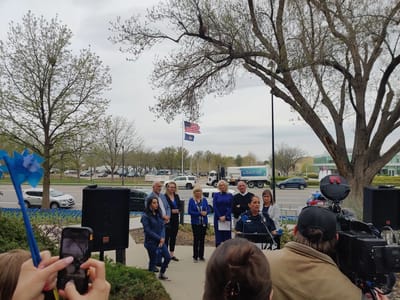 Outdoor gathering with people and flags present