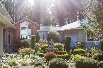 Beautifully landscaped garden area with flowers and fountain.