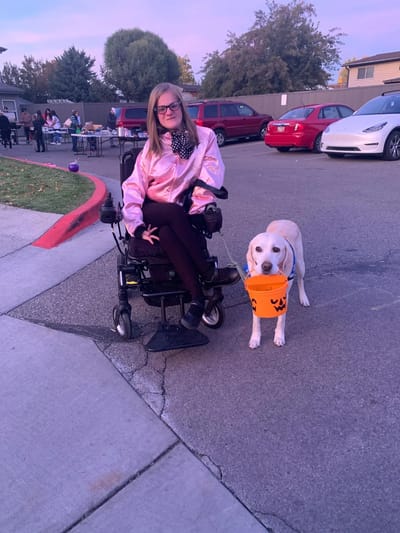 A young woman in a wheelchair with a dog.