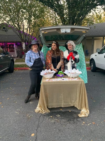 Three staff members at a community event with food.