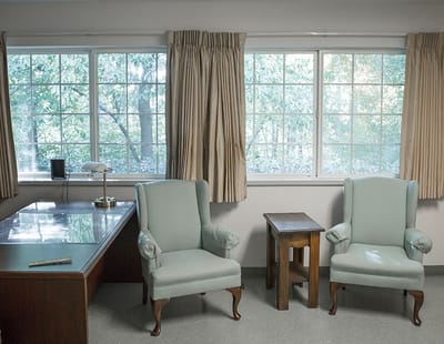Common area with chairs and a desk by the window.