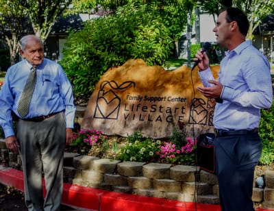 Two people speaking in a garden setting