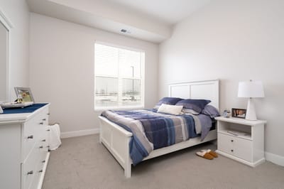 Cozy private bedroom with a bed and dresser.