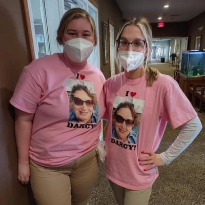 Staff members wearing pink shirts with a photo