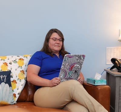 Staff member reading a colorful notebook.