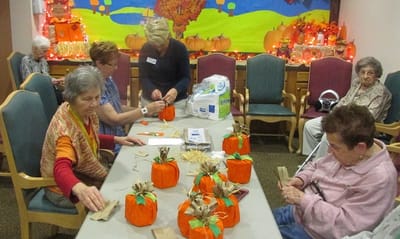 Residents engaged in a crafting activity with pumpkins.