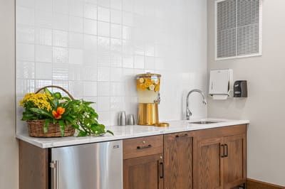 Kitchenette area with beverages and plants.